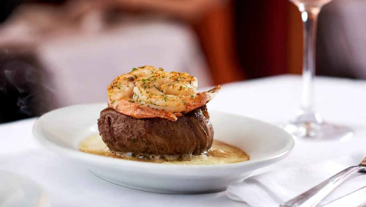 Juicy steak topped with grilled shrimp served at Ruth's Chris Steak House, showcasing premium American steakhouse cuisine and fine dining experience.