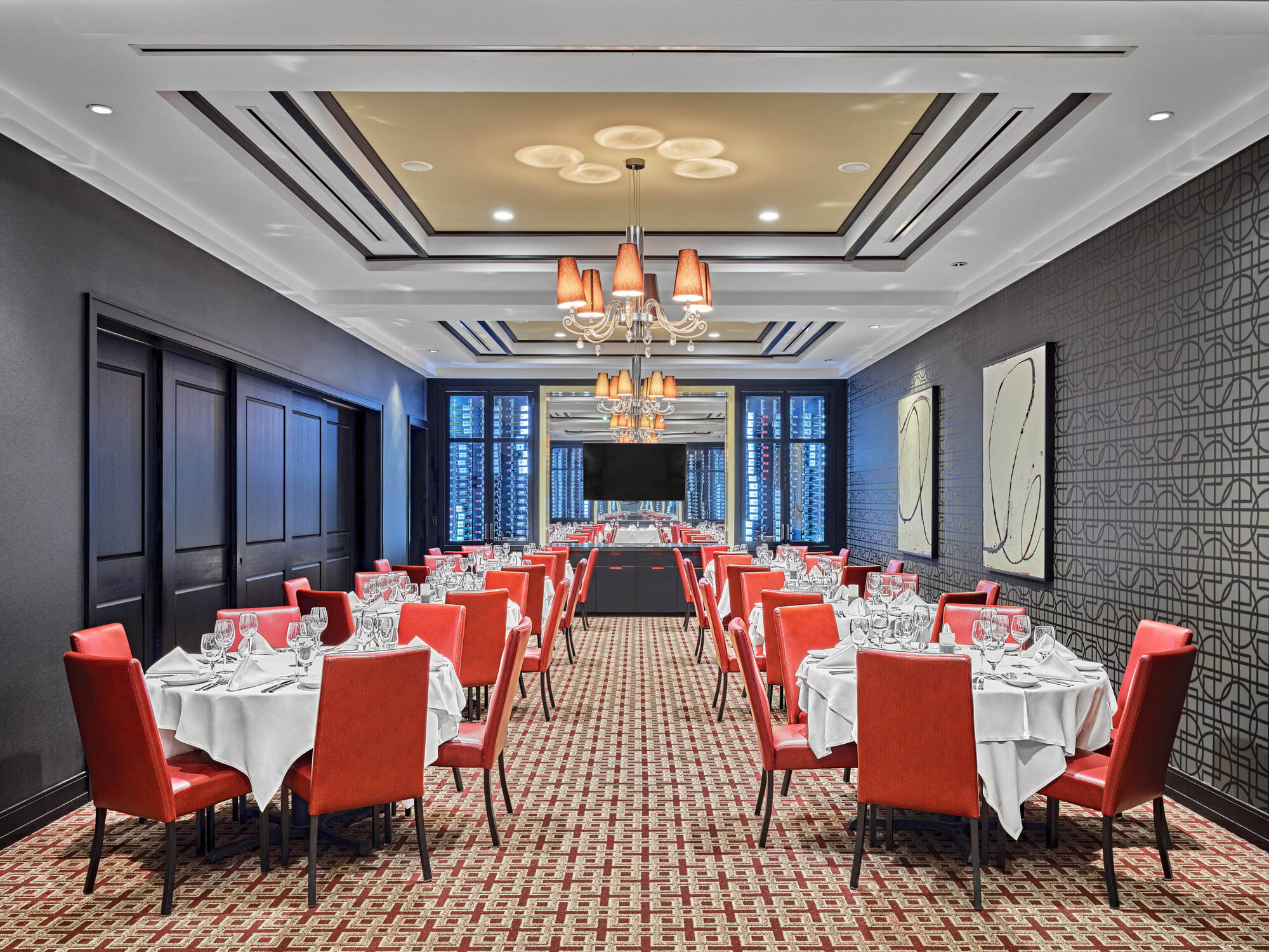 Elegant dining room at Ruth's Chris Steak House, featuring sophisticated decor, white tablecloths, and stylish red chairs, perfect for a upscale steakhouse experience and fine dining.